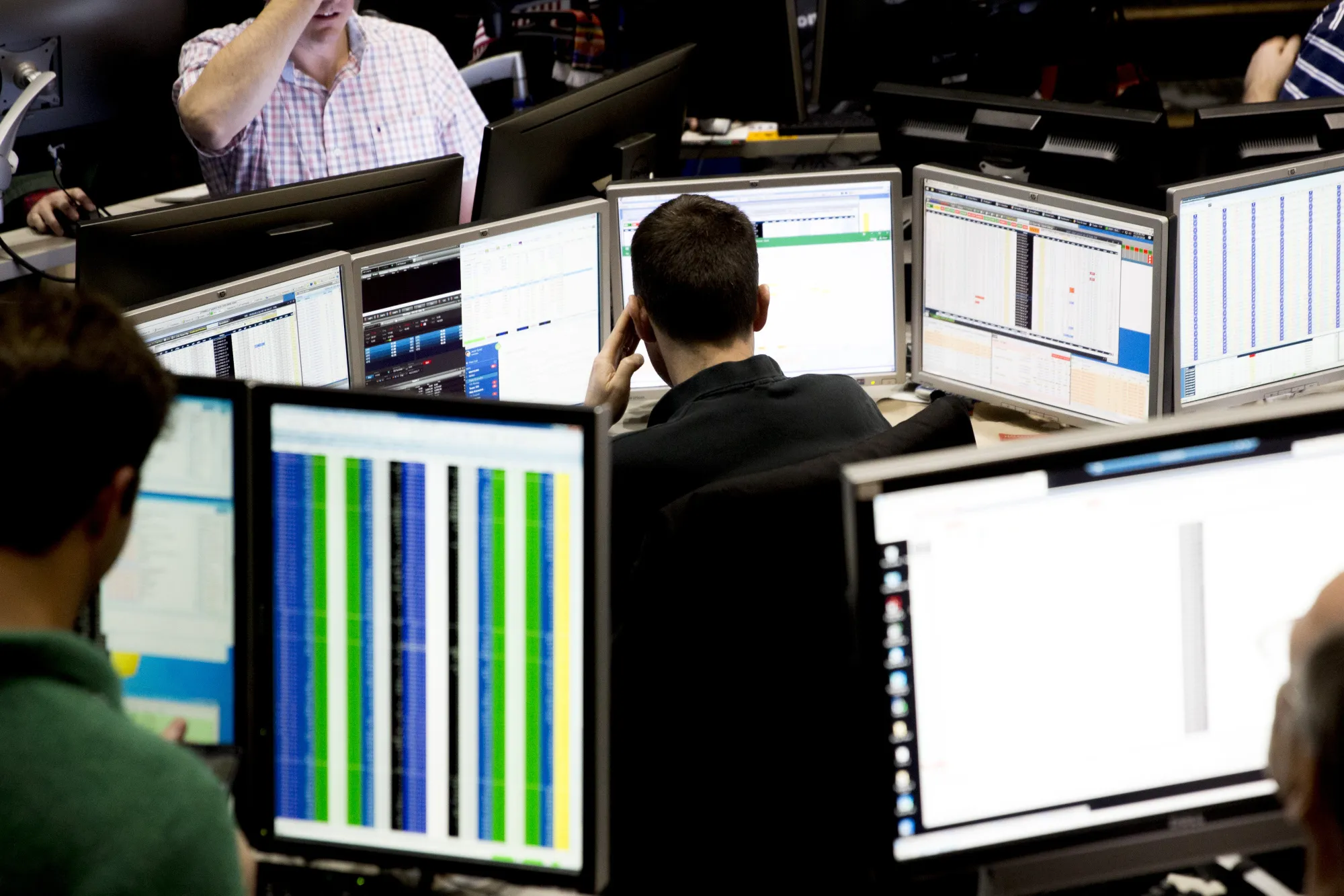 A London Stock Exchange sign in the foreground of a stock ticker display