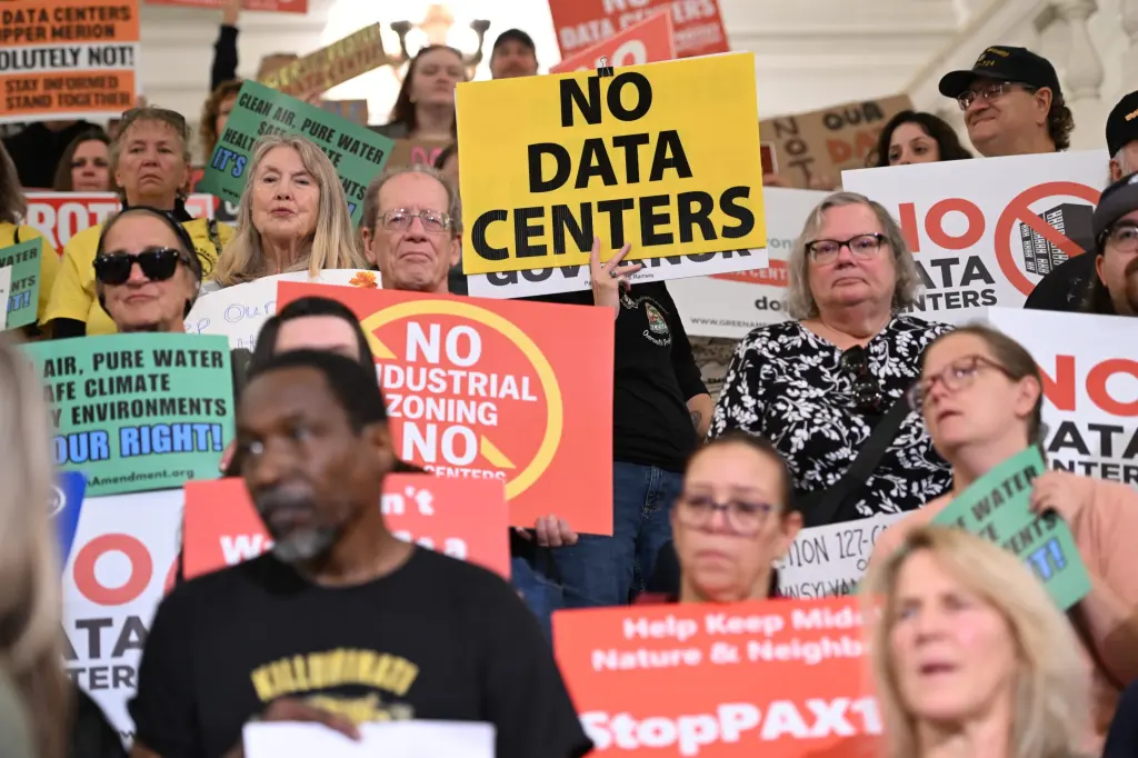 Protesters holding "No Data Centers" signs at a statehouse rally